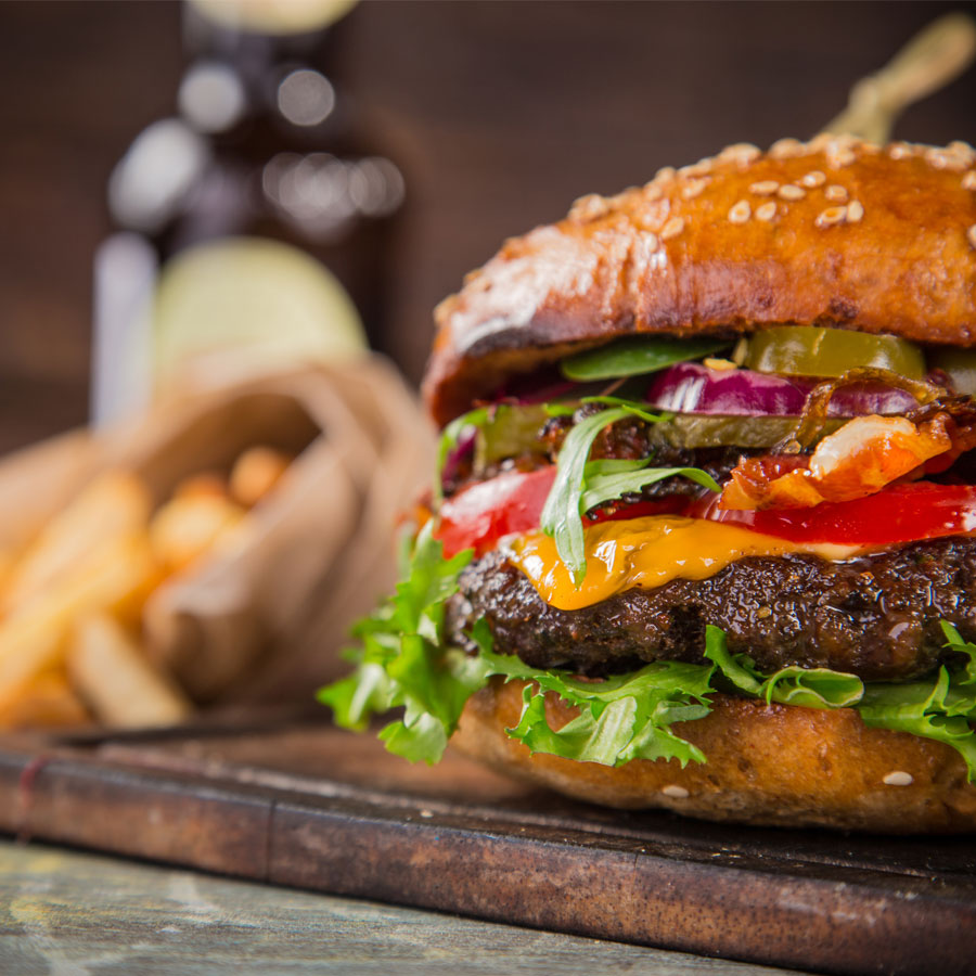 cheeseburger with fries on a cutting board